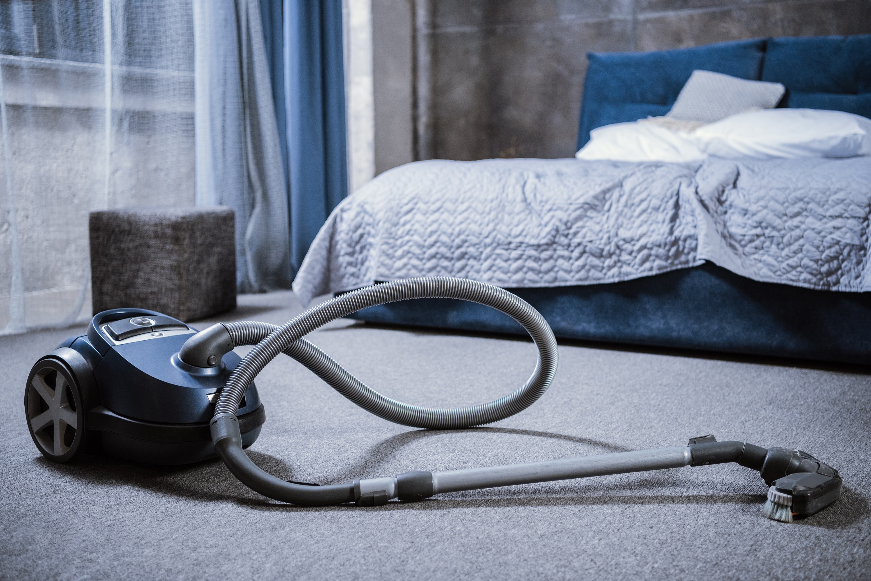 vacuum-cleaner-on-grey-carpet-in-bedroom-2021-08-29-10-18-41-utc.jpg