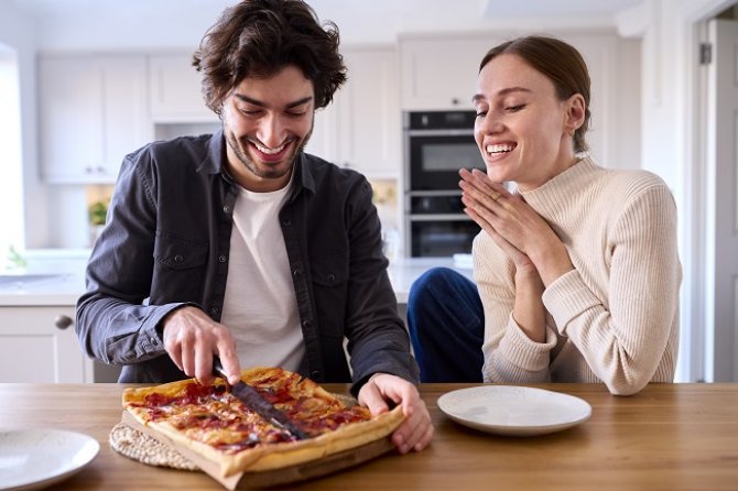 couple-in-kitchen-at-home-eating-homemade-pizza-si-2023-01-26-05-35-28-utc.jpg