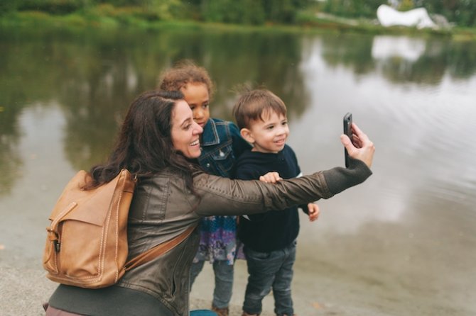 a-woman-taking-selfie-s-with-two-young-children-in-2022-11-15-22-46-14-utc.jpg