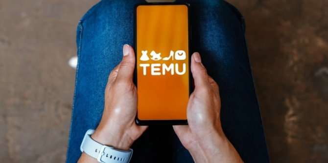 mlad&aacute; slečna pr&aacute;vě otev&iacute;r&aacute; aplikaci Temu na sv&eacute;m mobiln&iacute;m telefonu